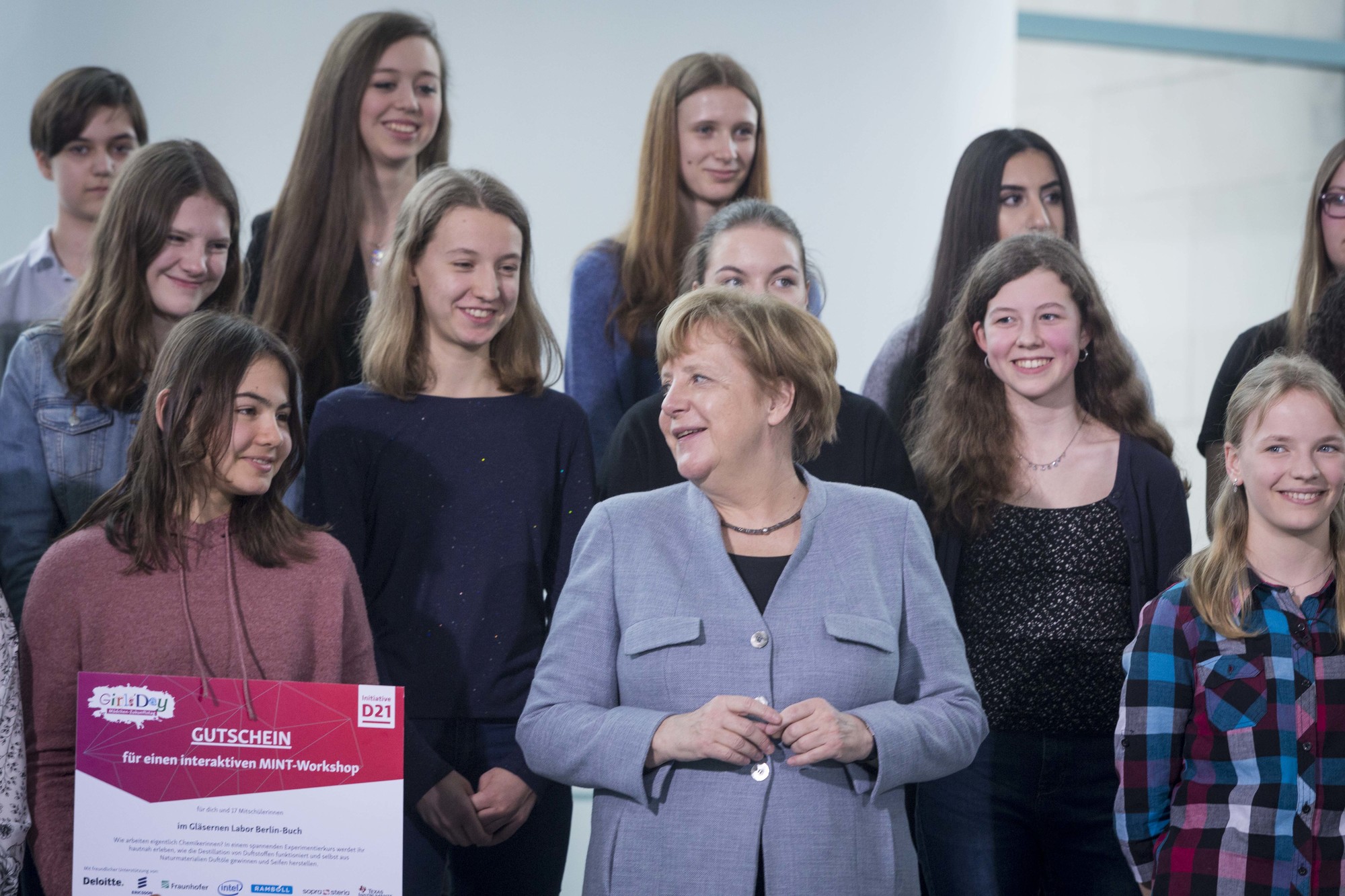 Bundeskanzlerin Angela Merkel steht neben Schülerinnen